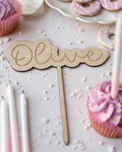 Load image into Gallery viewer, wooden birthday cake topper engraved with a name and surrounded by pink cupcakes and iced biscuits