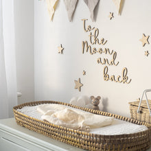 Load image into Gallery viewer, Wooden 'to the moon and back' nursery wall art sign on a white wall above a baby changing table, surrounded by wooden stars and neutral decor