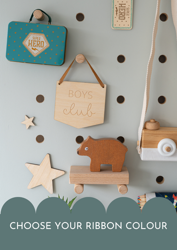 wooden boys club banner on an ochre coloured hanger hung on a blue peg board