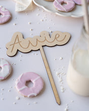 Load image into Gallery viewer, wooden personalised cake stick on a white background surrounded by white cake sprinkles and iced biscuits
