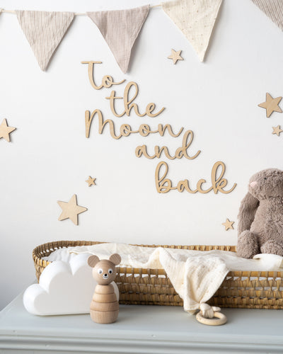 Wooden 'to the moon and back' wall art sign on a white nursery wall. 